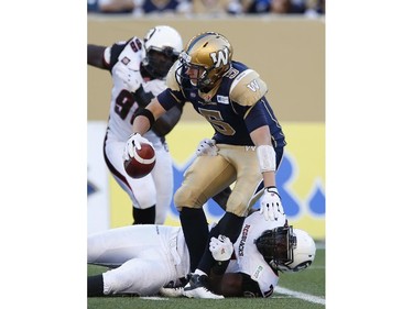 Winnipeg Blue Bombers' quarterback Drew Willy (5) gets sacked by Ottawa Redblacks' Jonathan Williams (75) during the first half of CFL action in Winnipeg Thursday, July 3, 2014.