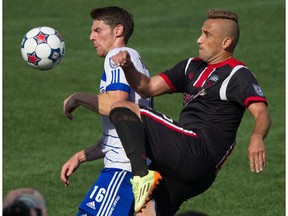 FC Edmonton's Daryl Fordyce, left, and Ottawa Fury FC's Maykon fight for the ball at Commonwealth Stadium in Edmonton on July 13, 2014. The game ended in a 0-0 tie.