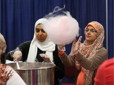 Eman Gazaria (L) and Noha Ahmed prepare cotton candy during Eid celebrations held at the EY Centre in Ottawa, July 28, 2014.