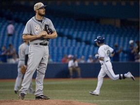 Ottawa native Erik Bedard has just been designated for assignment by Tampa. Here he looks on as Toronto Blue Jays Steve Tolleson, right, rounds the bases after hitting a solo home run  in Toronto in May.