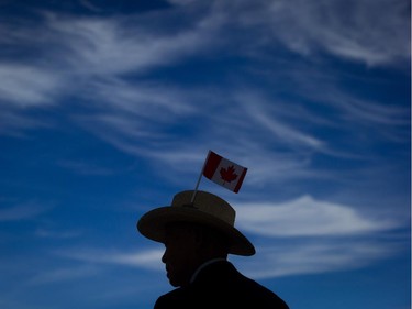 Errol Yim, 92, wears a Canadian flag on his hat as he takes in the view of the harbour during Canada Day celebrations in Vancouver, B.C., on Tuesday July 1, 2014.