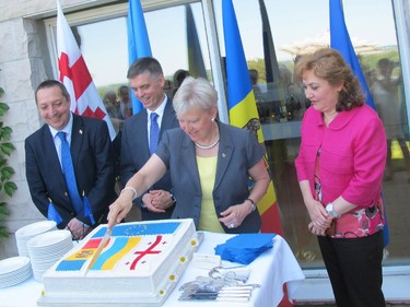 EU Ambassador Marie-Anne Coninsx cuts the cake at a reception to celebrate the signing of association agreements between the EU and Georgia, Moldova and Ukraine. Back row from left: Georgian Ambassador Alexander Latsabidze, Ukrainian Ambassador Vadym Prystaiko and Moldovan Ambassador Ala Beleavschi.