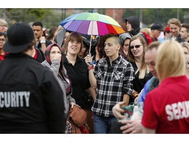 Fans look up to check for rain while waiting to get into Bluesfest opening night Thursday, July 3, 2014.