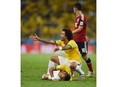 Brazil's defender Marcelo (R) gestures as Brazil's forward Neymar (L) lies on the pitch after being injured during the quarter-final football match between Brazil and Colombia at the Castelao Stadium in Fortaleza during the 2014 FIFA World Cup on July 4, 2014.