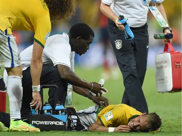 Brazil's forward Neymar (C) lies on the pitch after being injured during the quarter-final football match between Brazil and Colombia at the Castelao Stadium in Fortaleza during the 2014 FIFA World Cup on July 4, 2014.