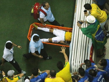 Fans react as Brazil's forward Neymar is carried off the pitch on a stretcher after being injured during the quarter-final football match between Brazil and Colombia at the Castelao Stadium in Fortaleza during the 2014 FIFA World Cup on July 4, 2014.