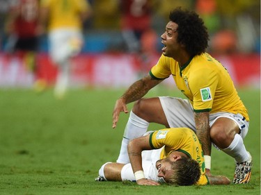 Brazil's defender Marcelo (R) gestures as Brazil's forward Neymar (L) lies on the pitch after being injured during the quarter-final football match between Brazil and Colombia at the Castelao Stadium in Fortaleza during the 2014 FIFA World Cup on July 4, 2014.