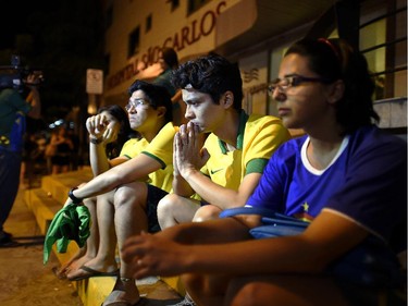 Brazil football fans sit outside Sao Carlos Hospital where superstar striker Neymar was treated after being injured during the quarter-final football match between Brazil and Colombia at the Castelao Stadium in Fortaleza during the 2014 FIFA World Cup on July 4, 2014. Brazil star Neymar was ruled out of the World Cup after that with a back injury, team doctor Rodrigo Lasmar said. Lasmar told reporters Neymar suffered a fracture in the third verterbra of his back during Brazil's bruising 2-1 quarter-final victory over Colombia.