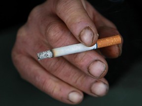 It was reported that tobacco company Reynolds American will purchase rival  Lorillard, maker of Newport for $27.4 billion SAN FRANCISCO - DECEMBER 15:  A man holds a cigarette outside of a tobacco store December 15, 2008 in San Francisco, California.  The U.S. Supreme Court ruled today that people may file lawsuits against tobacco companies for deceptive advertising of "light" cigarettes.