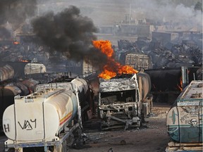 Flames rise from oil tankers after an attack claimed by Taliban militants on the outskirts of Kabul, Afghanistan, Saturday, July 5, 2014. An Afghan security official says at least 400 fuel tankers caught fire late Friday night in a parking lot in the outskirts of Kabul.