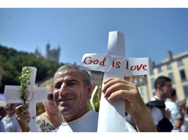 A man poses with a cross  during a rally on Saint-Jean Square in Lyon, central-eastern France, on July 26, 2014, to protest against the persecution Christians in Iraq by jihadists of the Islamic State (IS). The Islamic State, which last month declared a "caliphate" comprising large swathes of northern Iraq and Syria, has threatened a Christian presence in the region spanning close to two millennia. On July 21 the United Nations Security Council denounced militant persecution of Christians and other minorities in Iraq, warning such actions can be considered crimes against humanity.