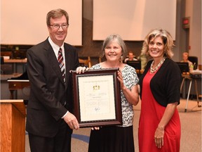 Catherine Burns receives the Mayor's City Builder Award from Mayor Jim Watson and Coun. Katherine Hobbs.