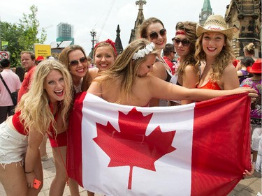 (from left) Meghan McMann, Frederique Duquette, Laura Castillani, Olivia Allen, Taylor Olson, Madison Skot-Niki, and Chloe Hutchison (centre with flag) having fun dressed in read and white as people flock to Parliament Hill and the downtown core to enjoy Canada's 147th birthday.