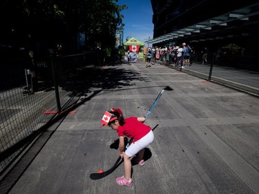 A young girl plays ball hockey during Canada Day celebrations in Vancouver, B.C., on Tuesday July 1, 2014.