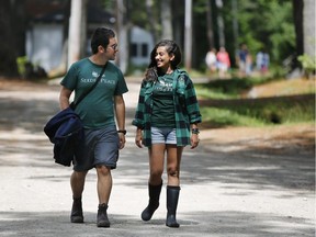 In this photo made Thursday, July 17, 2014,  camp counselors Hagai Dfrat, 23, of Israel, left, and Monica Baky of Egypt, talk while walking on the grounds of the Seeds of Peace camp in Otisfield, Maine. Counselors at the lakeside camp that has brought children together from countries at war for more than 20 years, said they are united by fear of the violence raging in the Middle East and a hope that their generation will be the one to end it.