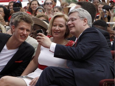 Prime Minister Stephen Harper and his wife Laureen take a "selfie" while their son Ben looks on during Canada Day celebrations on Parliament Hill in Ottawa, Tuesday, July 1, 2014.