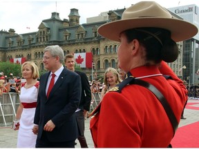 Laureen Harper, shown with husband Stephen and and their children Ben and Rachel on Canada Day, is sporting a purse by Ottawa designer Nina Saab.