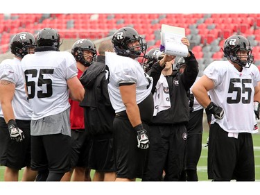 "Hello?" It looks as if very few of the players are paying attention as a playbook is gone over with some of the offensive linemen as the Ottawa Redblacks practice through a downpour Tuesday morning at TD Place Stadium at Lansdowne Park.