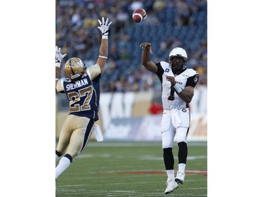 Ottawa Redblacks quarterback Henry Burris (1) throws a touchdown pass to Chevon Walker (29) as Winnipeg Blue Bombers' Teague Sherman (27) attempts to knock it down during the first half of CFL action in Winnipeg Thursday, July 3, 2014.