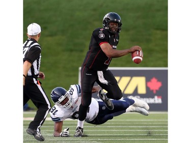 Henry Burris of the Ottawa Redblacks is tackled by Tristan Okpalaugo of the Toronto Argonauts at TD Place in Ottawa during the franchise home opener of the Redblacks on Friday, July 18, 2014.