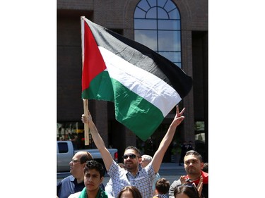 Hundreds, including Mohammed Awni, rally in support of Palestine at the Human Rights Memorial in Ottawa, Saturday, July 12, 2014. Many brought banners and flags, and chanted, and later, they marched toward another rally in front of the US embassy on Sussex Dr.