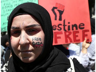 Hundreds of people gathered in support of Palestine at the Human Rights Memorial in Ottawa, Saturday, July 12, 2014. Many brought banners and flags, and chanted, and later, they marched toward another rally in front of the US embassy on Sussex Dr.