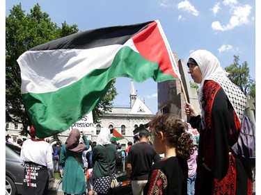 Hundreds of people gathered to support Palestine at the Human Rights Memorial in Ottawa, Saturday, July 12, 2014. Many brought banners and flags, and chanted, and later, they marched up Elgin St. toward the US embassy on Sussex Dr.