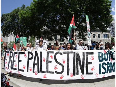 Hundreds of people rally in support of Palestine at the Human Rights Memorial in Ottawa, Saturday, July 12, 2014. Many brought banners and flags, and chanted, and later, they marched toward another rally in front of the US embassy on Sussex Dr.