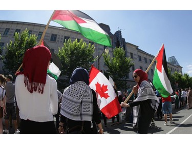 Hundreds of people rally in support of Palestine in front of the US embassy on Sussex Dr. in Ottawa, Saturday, July 12, 2014. Many carried banners and flags, and others chanted.