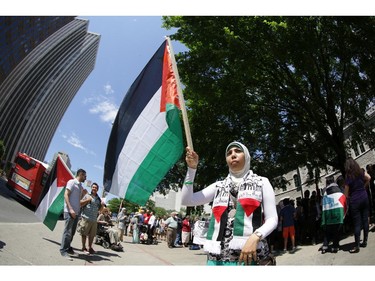 Hundreds of people rally, including Khadija Elnilali, age 16, of Ottawa, in support of Palestine at the Human Rights Memorial in Ottawa, Saturday, July 12, 2014. Many brought banners and flags, and chanted, and later, everyone marched up Elgin St. toward another rally in front of the US embassy on Sussex Dr.