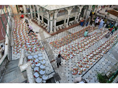 Indian Muslims lay out food for Iftar, the breaking of fast during Ramadan at the Alif Ni Masjid in Ahmedabad on July 27, 2014.   The Iftar, for people who come to shop in the Teen Darwaja area of Ahmedabad, was organised by the Khwaja Garib Nawaz Khidmat Patharna Bazar.  Across the Muslim world, the faithful fast from dawn to dusk and abstain from eating, drinking, smoking and having sex during the Holy Month of Ramadan as they strive to be more pious and charitable.