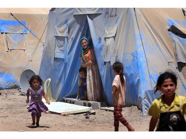 Iraqi displaced children, who fled with their families violence in the northern city of Tal Afar, walk past tents at Khazer refugee camp near the Kurdish checkpoint of Aski kalak, 40 km West of Arbil, the capital of the autonomous Kurdish region of northern Iraq on July 27, 2014. Thousands of Christians and other minorities have fled the northern city of Mosul and other areas after a jihadist onslaught led by Islamic State insurgents swept swathes of Iraq's north and west the month before.