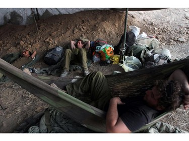 Israeli soldiers rest at an army deployment near the border between Israel and the Hamas-controlled Gaza Strip on July 26, 2014. Israel approved a four-hour extension of a temporary truce in Gaza, Israeli television said, after the Palestinian death toll topped 1,000 with the retrieval of more than 130.