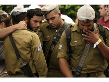 Comrades of 20-year-old Israeli army St. Sgt. Amit Yeori mourn during his funeral at the Mount Herzl military cemetery in Jerusalem, on July 27, 2014, after he was killed on July 25 during combat in the southern Gaza Strip. The Islamist Hamas movement continued firing rockets at Israel, despite claims it had accepted a UN request for a 24-hour extension of a humanitarian truce in war-torn Gaza.