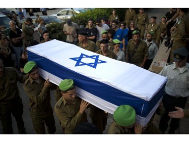 Israeli soldiers carry the coffin of 2nd Lt. Roy Peles, an infantry officer, during his funeral at Kiryat Shaul military cemetery in Tel Aviv, Israel, Sunday, July 27, 2014. Peles, 21, was killed in combat on Saturday in the Gaza Strip.