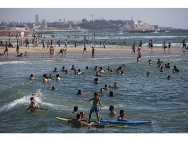 Israelis and tourists enjoy the Mediterranean Sea beachfront during a humanitarian cease-fire in the Gaza war, in Tel Aviv, Israel, Saturday, July 26, 2014. Israel agreed Saturday to extend a 12-hour humanitarian truce in the Gaza war by four hours, a Cabinet minister said. In Gaza, a health official said the Palestinian death toll in 19 days of fighting had surpassed 1,000.