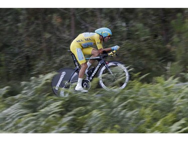 Italy's Vincenzo Nibali, wearing the overall leader's yellow jersey, strains during the twentieth stage of the Tour de France cycling race, an individual time-trial over 54 kilometers (33.6 miles) with start in Bergerac and finish in Perigueux, France, Saturday, July 26, 2014.