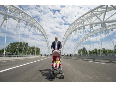 Jason Kelly walks his daughter Avaleigh, 1 across the deck of the Strandherd-Armstrong Bridge during its grand opening  in Ottawa on Saturday, July 12, 2014. The bridge connects the communities of Barrhaven and Riverside South over the Rideau River.