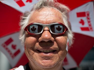 Jerry Johnston wears patriotic sunglasses and an umbrella bearing Canadian flags during Canada Day celebrations in Vancouver, B.C., on Tuesday July 1, 2014.
