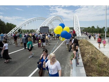 Jessica Thompson holds balloons during the grand opening of the Strandherd-Armstrong Bridge in Ottawa on Saturday, July 12, 2014. The bridge connects the communities of Barrhaven and Riverside South over the Rideau River.