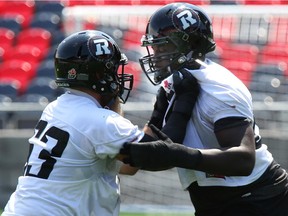 J'Micheal Deane (R) of the Ottawa Redblacks works on his offensive line skills against Jon Gott during practice at TD Place.