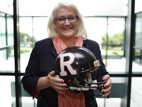 Jo-Anne Polak, now the vice-president of communications at Canada Post, holds the helmet of quarterback Damon Allen who played for the Ottawa Rough Riders (1989-1991) when Polak was co-general manager of the team.