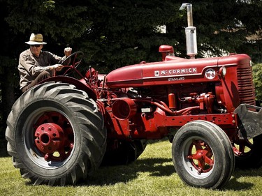 John Reid, of Cremona, Alta., drives a 1954 Harvester International tractor on his way to competing in a tractor pull during Canada Day celebrations in Cremona, Alta., Tuesday, July 1, 2014.