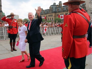 Governor General David Johnston waves as he and his wife Sharon along with Prime Minister Stephen Harper (right) arrive for Canada Day celebrations on Parliament Hill in Ottawa, Tuesday July 1, 2014.