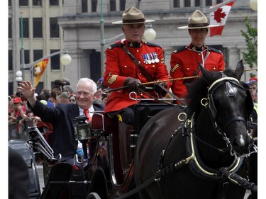 Governor General David Johnston arrives by horse-drawn landau with RCMP outriders for Canada Day celebrations on Parliament Hill in Ottawa, Tuesday July 1, 2014.