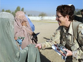 Kandahar, Afghanistan. 21 November 2009- Sgt Tanya Casey, a volunteer from the Camp Nathan Smith, greets an Afghan woman during the celebration of Eid al-Adha organized by the Kandahar Provincial Reconstruction Team where bags of flour, prayer carpets and tea were donated.