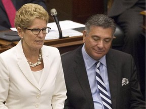 Ontario's Premier Kathleen Wynne (left) sits with Finance Minister Charles Sousa as they attend the Throne Speech at Queens Park in Toronto on Tuesday July 3, 2014.