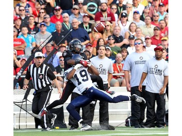 Kierrie Johnson of the Ottawa Redblacks can't handle the pass as he is tackled by Jalil Carter of the Toronto Argonauts at TD Place in Ottawa during the franchise home opener of the Redblacks on Friday, July 18, 2014.