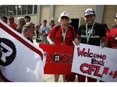 Charlie, left, Julie and James Jackson get into the spirit before the Redblacks' home opener at TD Place on Friday, July 18, 2014.