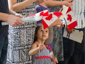 Lucy Galoyan, 3, waves the flag while her mother, Araksya Mirzoyan, receives her citizenship.